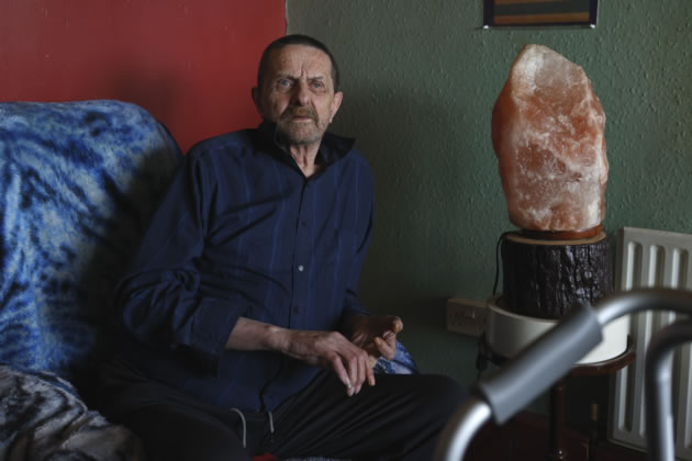 Phil Robinson poses for photos in his house in the Harlech tower